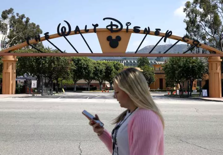 Una persona que pasa por la puerta de The Walt Disney Studios en Burbank, California. Foto: EFE
