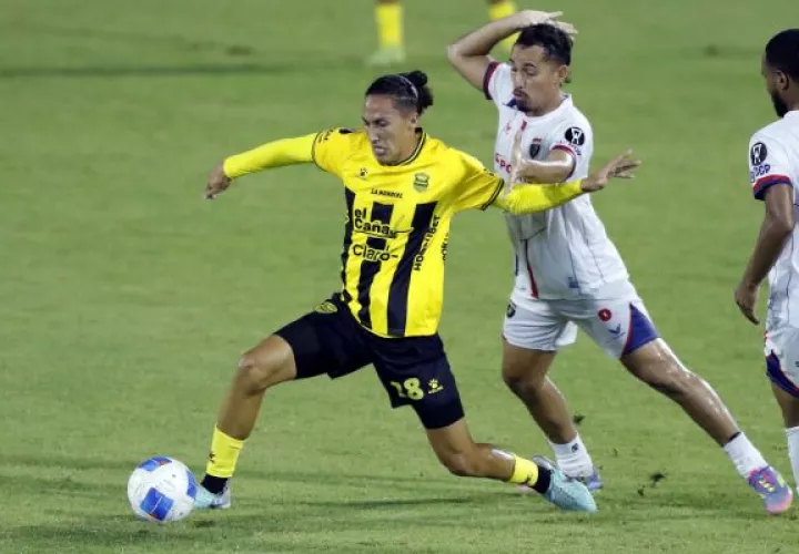 Carlos Mejía (izq.) de Real España disputa el balón con Joel Lara de Plaza Amador. Foto:EFE