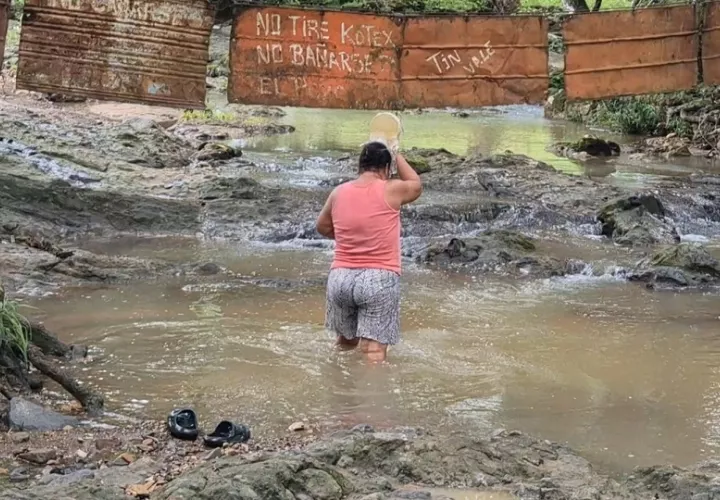 Para sobrevivir, los residentes deben cargar diariamente el agua desde una quebrada cercana, utilizando tanques, carretillas y baldes, o bien hacer su aseo personal en el mismo lugar. Foto. Thays Domínguez
