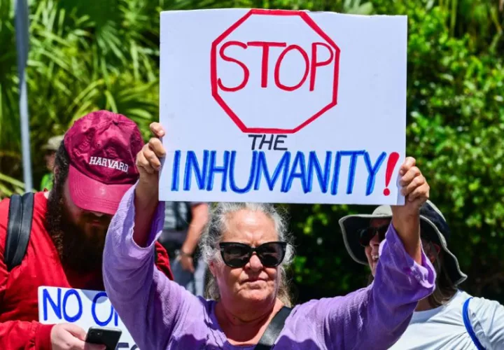 Una persona sostiene un cartel durante una manifestación contra las redadas de inmigrantes. Foto: EFE