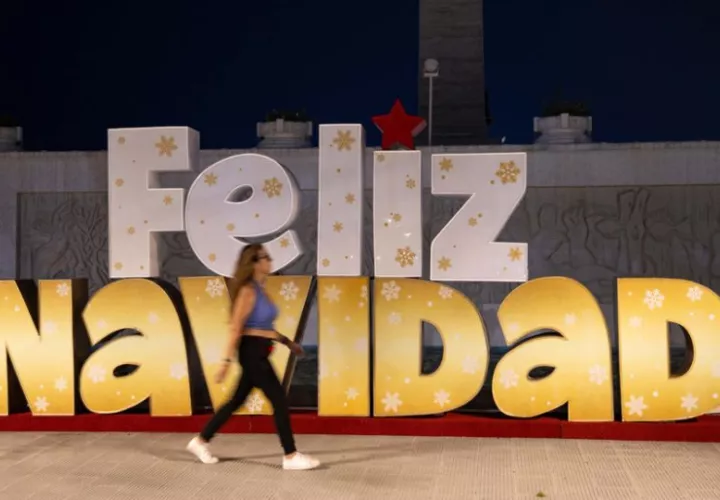 Una persona camina frente a decoración navideña este martes, en Caracas (Venezuela)