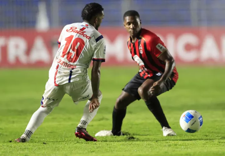 Armando Cooper del Sporting (der.) y Alberto 'Negrito' Quintero, de Plaza Amador (19) disputan el balón. Foto: EFE