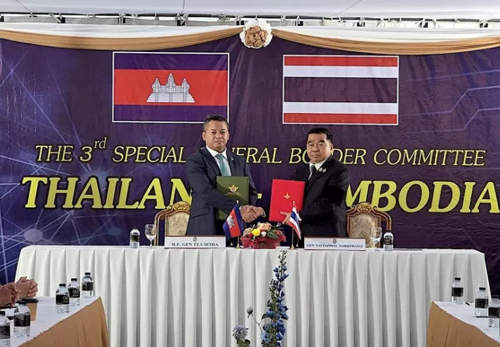 Tea Seiha (I) y Natthaphon Narkphanit (D), los ministros de Defensa de Camboya y Tailandia, respectivamente, intercambian el acuerdo firmado de cese al fuego. Foto: EFE