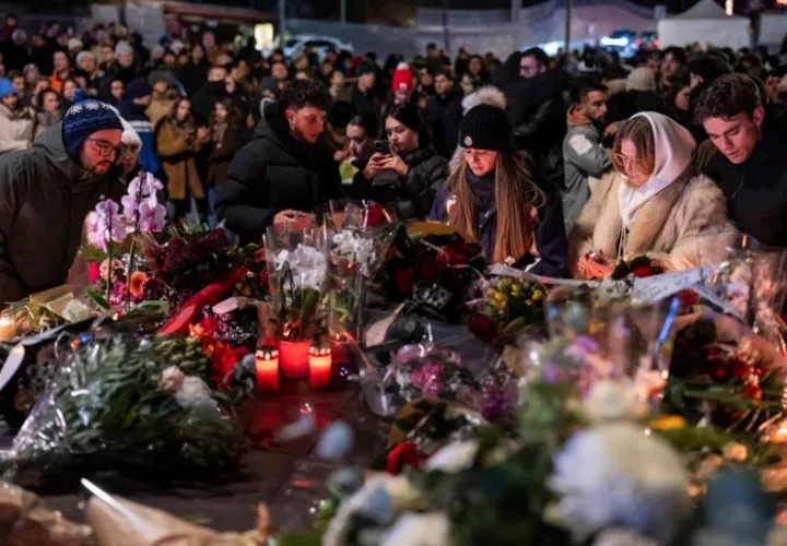 Cientos de dolientes depositan flores y encender velas para recordar a las víctimas del incendio en un bar en Suiza. Foto: EFE