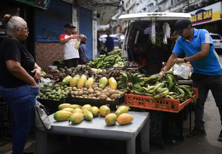 Personas compran frutas y verduras en la avenida Central este miércoles, en Ciudad de Panamá. EFE