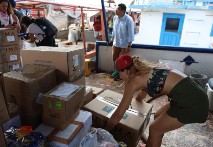 Activistas suben ayuda humanitaria a un buque con destino a Cuba. Foto: EFE