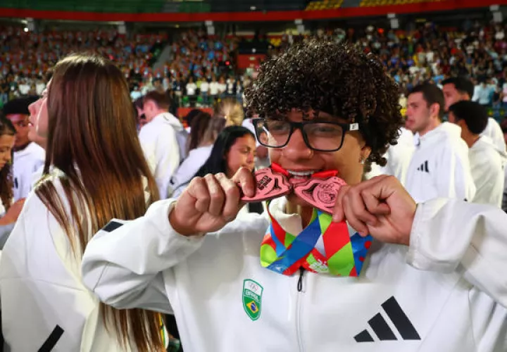 Un atleta de Brasil muestra sus medallas ganadas. Foto: EFE