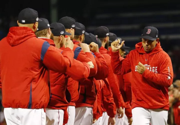 Alex Cora (dcha.) saluda a sus jugadores. AP