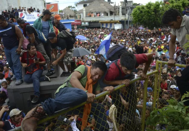 Desafiando la presencia policial un grupo de migrantes pasa la frontera hacia Guatemala. EFE 