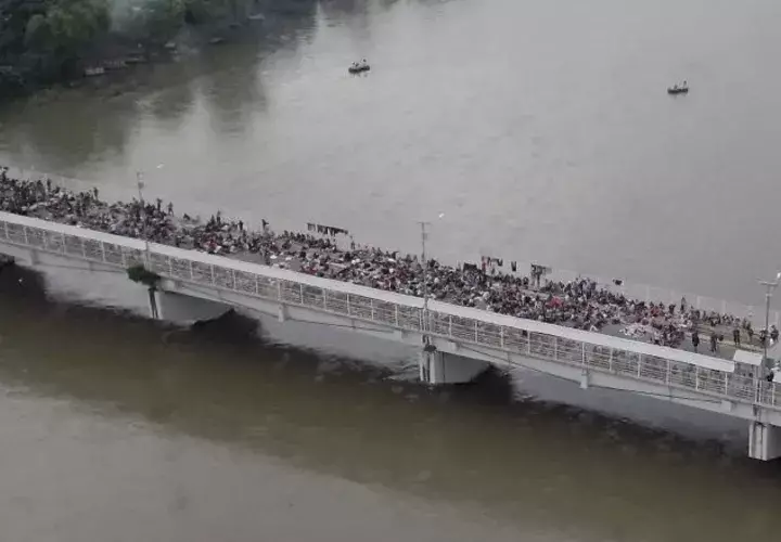 Al menos un millar de migrantes permanecen aparcados en el puente fronterizo en espera de ser atendidos. EFE