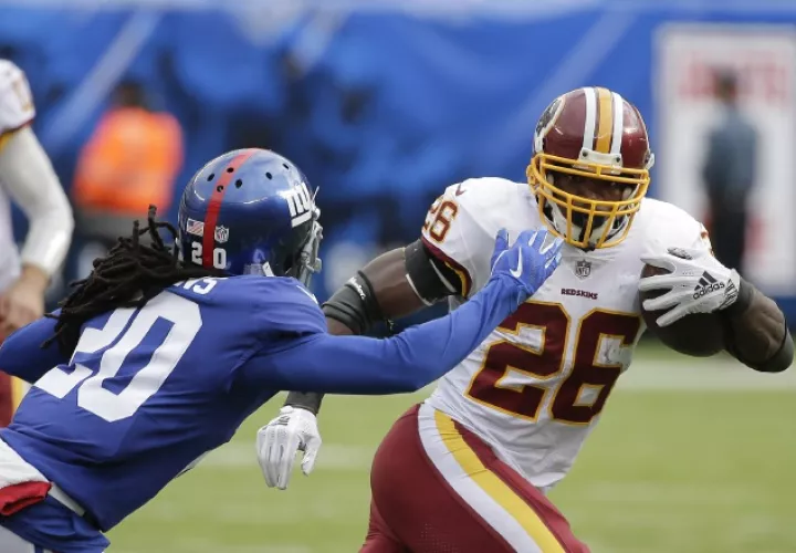 Adrian Peterson (26) trata de eludir a Janoris Jenkins. /Foto AP