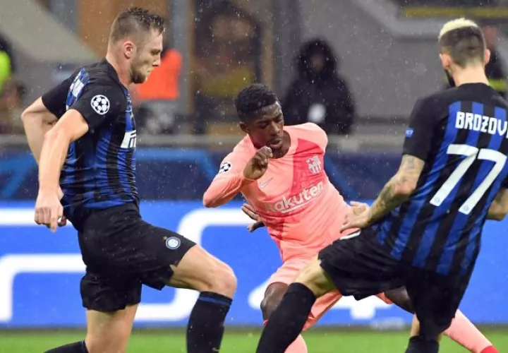 Ousmane Dembele, del Barcelona (c), disputa el balón contra Skriniar (i) y Brozovic (d), del Inter. /Foto EFE