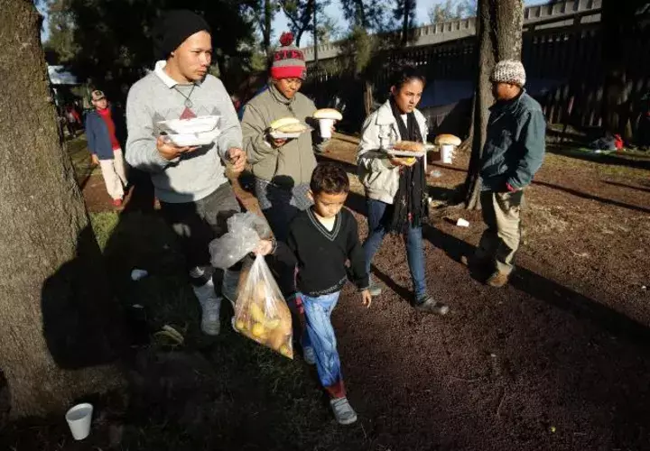 Migrantes reciben comida en el deportivo Jesús Martínez Palillo, en Ciudad de México. EFE