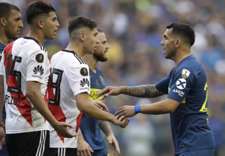 Carlos Tévez, de Boca Juniors, da la mano a Rafael Borre de River. /Foto: AP