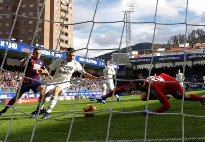 El portero Courtois no puede detener el balón ante el remate de Gonzalo Escalante (izq.) del Eibar. /Foto EFE