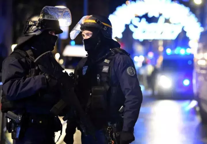 Oficiales de policía hacen guardia cerca a donde podría ubicarse al atacante tras un tiroteo mortal, en el Mercado de Navidad. EFE