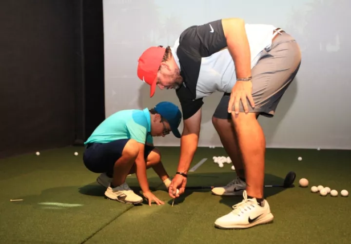 Mike Norman,  durante una clase con el golfista infantil Sebastián Paz Rodríguez. Anayansi Gamez