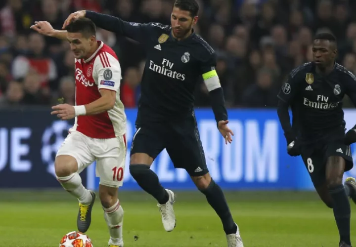 Dusan Tadic, del Ajax (izq.), es  marcado por Sergio Ramos. AP