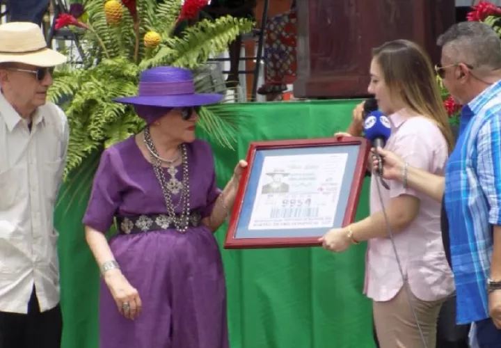 Sheila Lichacz cuando recibe el reconocimiento de la Lotería Nacional de Beneficencia. La Acompaña su esposo John (primero a la izquierda). Foto: Cortesía. 