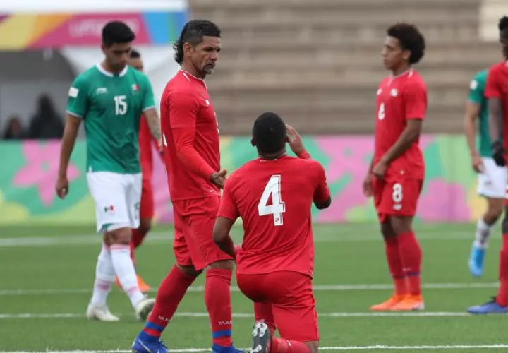 Manuel 'Cholo' Torres levanta a  Emmanuel Chanis (4) de Panamá, luego del empate ante México en los Panamericanos. EFE