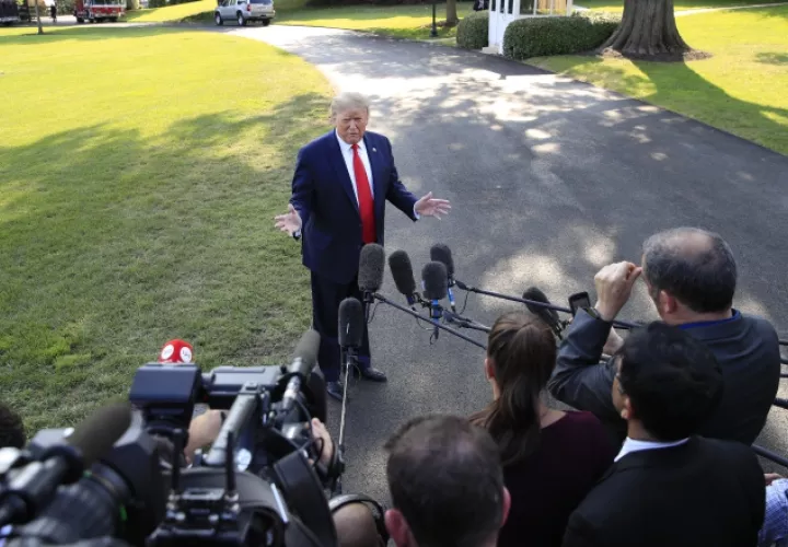 El presidente Donald Trump, atiende a un grupo de periodistas que lo cuestionan sobre Irán. FOTO/AP