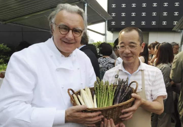 Alain Ducasse con un manojo de espárragos en Japón.