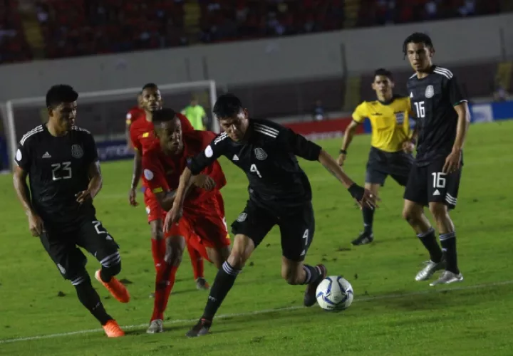 Gabriel 'Gaby' Torres es marcado por los mexicanos Edson Álvarez (4) y Jesús Gallardo (23).  Anayansi Gamez
