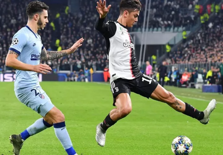 Paulo Dybala de la Juevntus (der.) y Mario Hermoso del Atlético. AP
