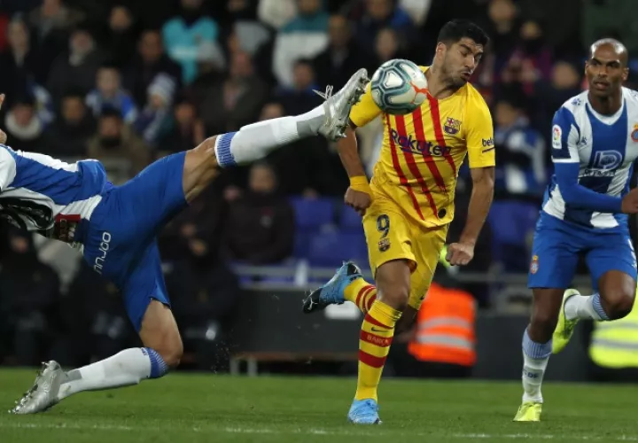 Bernardo Espinosa del Espanyol despeja el balón ante el acecho de Luis Suárez del Barcelona. AP