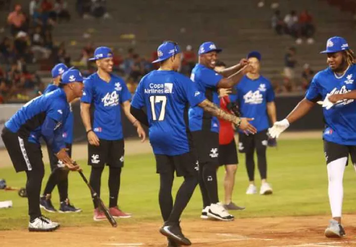 Vladimir Guerrero Jr. anota una carrera para el Equipo Azul ante el saludo de Johan Camargo. Anayansi Gamez