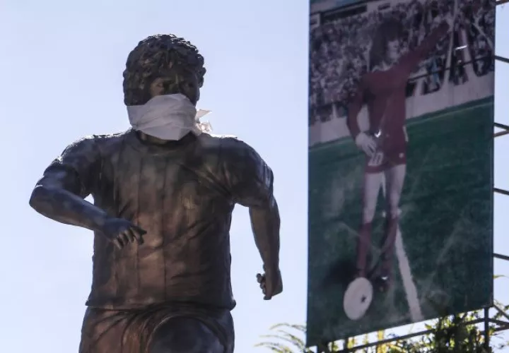 La estatua de Diego Armando Maradona luce un tapabocas.  EFE