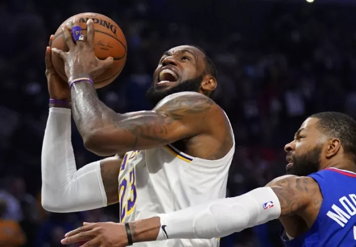LeBron James de los Lakers es marcado por  Marcus Morris de los Clippers en un partido de la NBA. AP