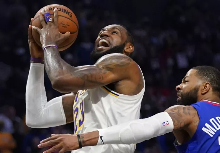 LeBron James (izq)de los Lakers anota una canasta ante Marcus Morris de losnClippers  AP