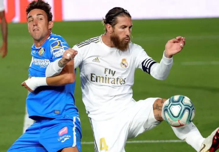 El defensa del Real Madrid, Sergio Ramos (der.) despeja el balón ante el delantero del Getafe, Jaime Mata. Foto:EFE