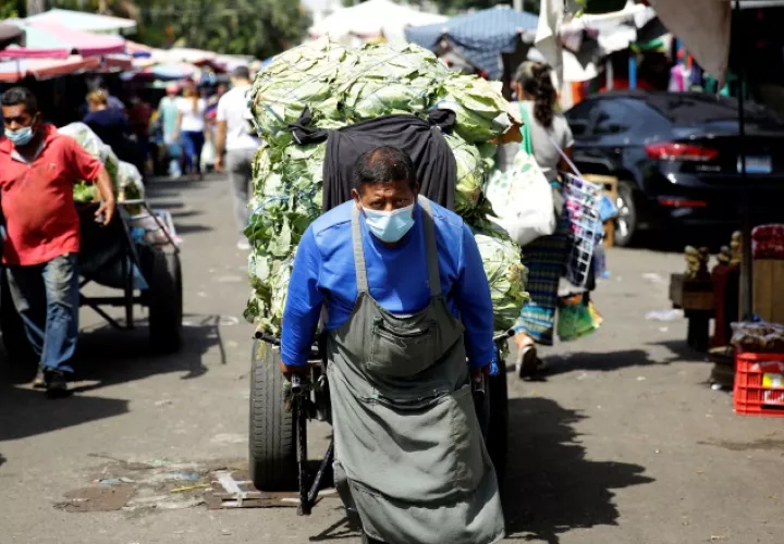 Vendedor en un mercado de El Salvador, país en donde los casos de COVID-19 aumentaron en 200% . EFE