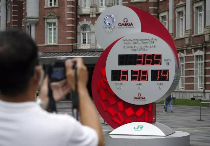 Un afcionado toma una foto del reloj que lleva el tiempo aplazado de los Juegos de Tokio. Foto:EFE