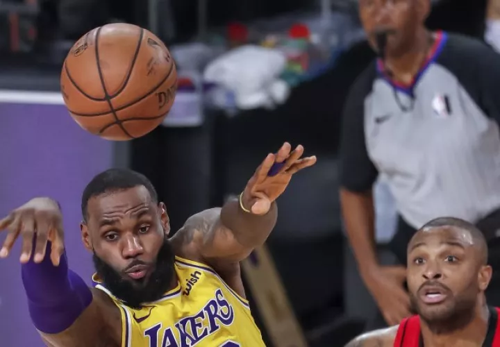 LeBron James (Izq.)  de los Lakers, cede el balón ante la mirada de  P.J. Tucker de los Rockets. Foto:EFE