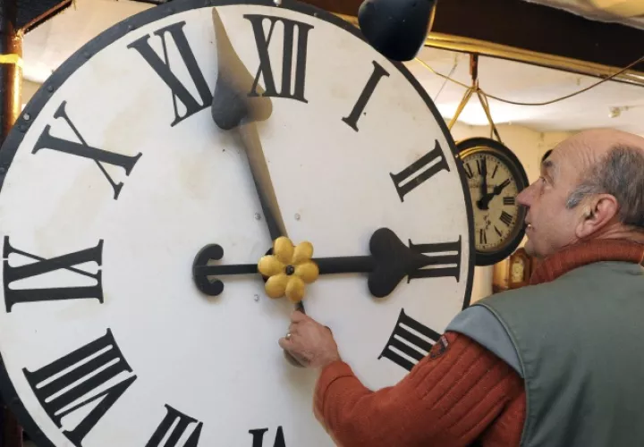 Peter Leonardy, examina un reloj fabricado alrededor del año 1900.