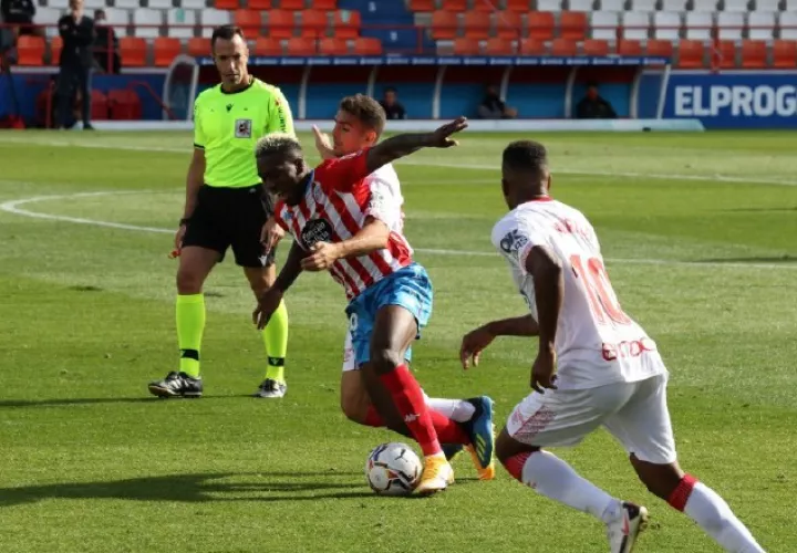 El panameño José Luis 'Puma' Rodríguez del Lugo (centro) es agarrado por un jugador del Mallorca. Foto@CDeportivoLugo
