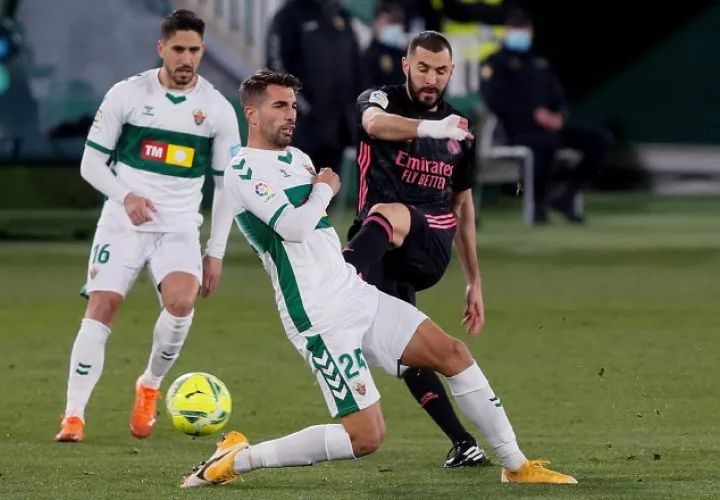 El delantero francés del Real Madrid, Karim Benzema (der.),  patea el balón ante el defensa del Elche, Josema. Foto:efe