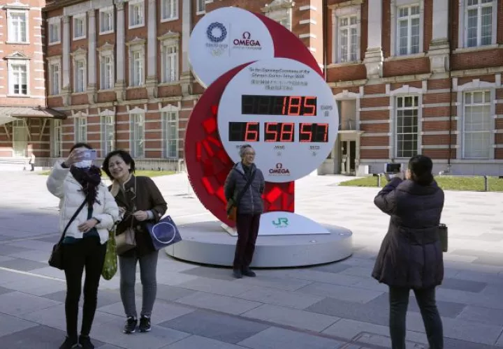 Los transeúntes posan ante un reloj de cuenta atrás de los Juegos Olímpicos. Foto:EFE
