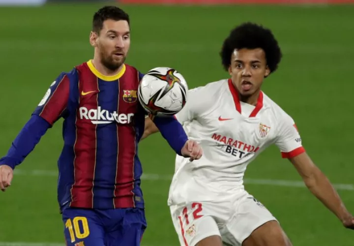 El defensa francés del Sevilla Jules Koundé (d) pelea un balón con el delantero argentino del Barcelona, Messi. Foto:EFE
