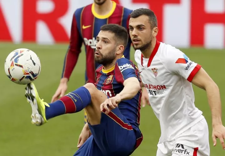 El defensa del Barcelona Jordi Alba (izq.) controla el balón ante el centrocampista del Sevilla Joan Jordán  Foto:EFE