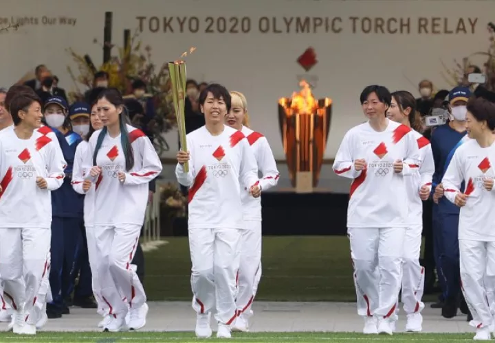 Azusa Iwashimizu (cent.) y otros miembros del equipo de fútbol femenino de Japón corren como portadores de la antorcha. Foto:EFE