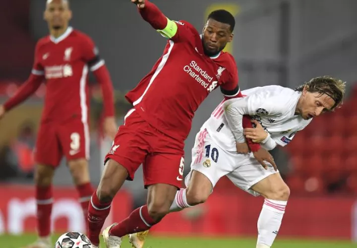 Georginio Wijnaldum del Liverpol es sujetado por  Luka Modric del Real Madrid. Foto:EFE