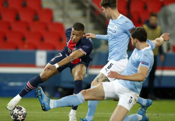 Kylian Mbappé del PSG intenta dominar el balón ante la marca de dos jugadores del Manchester City. Foto:EFE