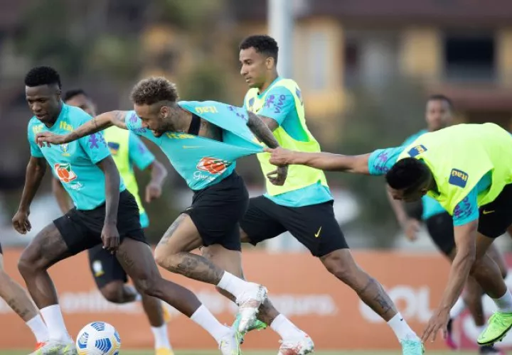 Neymar, sujetado por un compañero durante los entrenamientos. Foto:EFE