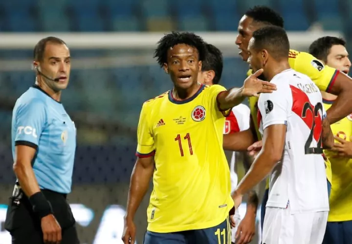 Juan Guillermo Cuadrado de Colombia discute una jugada durante el partido contra Perú. Foto:EFE