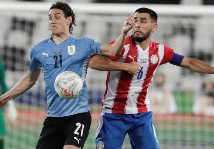 Edinson Cavani (izq.) de Uruguay disputa el balón con Junior Alonso de Paraguay. Foto:EFE
