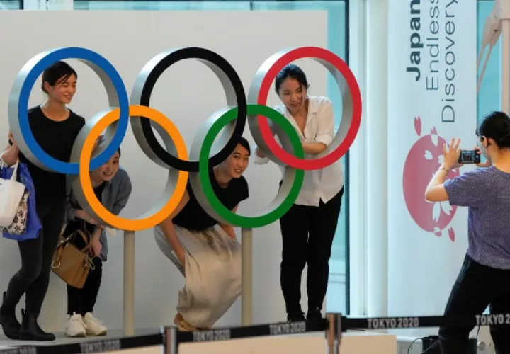 Aficionados posan con la argollas olímpicas en Tokio. Foto:EFE